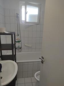 een badkamer met een wastafel en een toilet en een raam bij Ganze Wohnung mit privatem Balkon in Gelsenkirchen