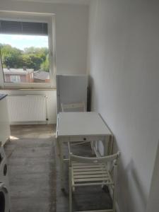 een tafel en een stoel in een kamer met een raam bij Ganze Wohnung mit privatem Balkon in Gelsenkirchen +10 foto's