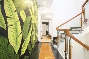 a hallway with a mural of leaves on the wall at Lagoon Homestay Hoi An in Hoi An