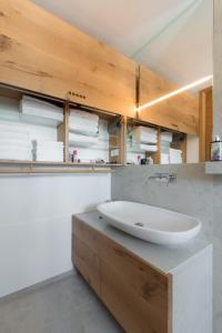a bathroom with a white sink and wooden cabinets at Apartment Beta in Izola +21 photos
