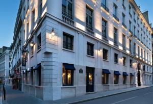 a building on a city street with lights on it at Hôtel Square Louvois in Paris