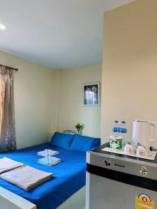 a room with a bed with a blue sheets and a counter at Pepa Guest House in Koh Tao