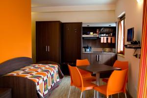 a room with a bed and a table and chairs at Residence Coccinella in Torre Melissa