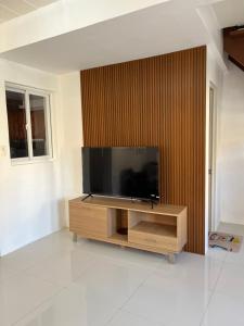 einen Flachbild-TV auf einem hölzernen Entertainment-Center in der Unterkunft Jorich home stay in Dumaguete