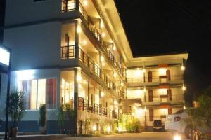 a lit up building at night with lights at Nan Treasure Hotel in Ban Hua Wiang Nua
