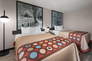 a hotel room with two beds and a lamp at Super 8 by Wyndham Kent/Akron Area in Kent