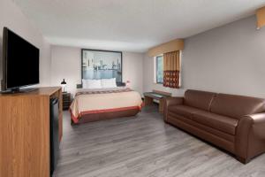 a hotel room with a bed and a flat screen tv at Super 8 by Wyndham Kent/Akron Area in Kent