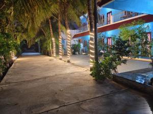 een hal van een gebouw met palmbomen en verlichting bij Srinivasa Residency in Mahabalipuram