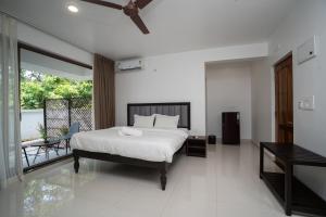 a bedroom with a bed and a balcony at Mistral by the sea in Benaulim +31 photos