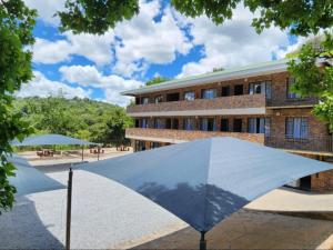 un ombrello blu di fronte a un edificio di Malachite Rest a Nelspruit