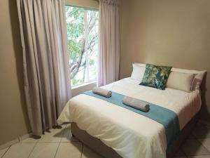 un letto in una stanza con una finestra di Malachite Rest a Nelspruit