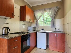 una cucina con mobili in legno e un forno a piano cottura di Malachite Rest a Nelspruit