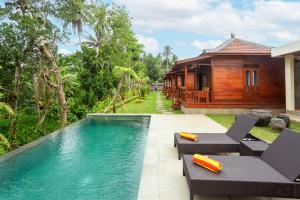 a resort with a swimming pool and a house at Pondok Naples Ubud in Ubud