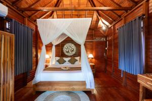 a bedroom with a bed in a wooden house at Pondok Naples Ubud in Ubud