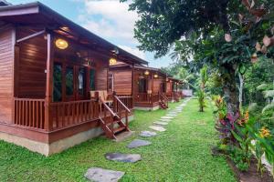 a row of wooden cottages in a garden at Pondok Naples Ubud in Ubud