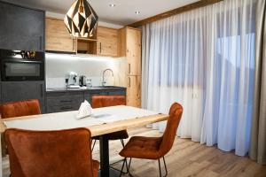 a kitchen and dining room with a table and chairs at Moonlight Apartments in Söll