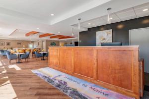 a restaurant with a reception desk and a bar at Casco Bay Hotel Portland Airport - Maine Mall, an Ascend Collection Hotel in South Portland
