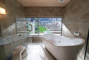 een badkamer met een bad en een raam bij Sou in Isahaya +30 foto's