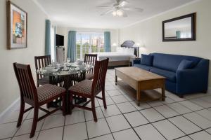 a living room with a table and a blue couch at Coconut Malorie Resort Ocean City, Ascend Collection Hotel in Ocean City