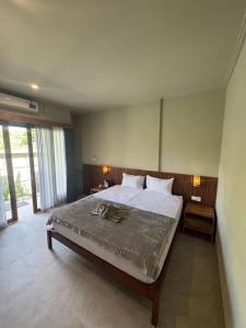 a bedroom with a large bed and a large window at Hepy Hotel in Kuta Lombok
