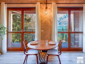 a dining room with a table and chairs and windows at THE LOFT by Design Studio in Bellano