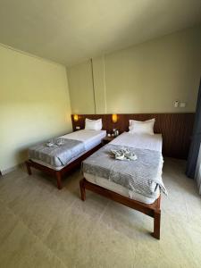 twee bedden in een kamer met twee bedden bij Hepy Hotel in Kuta Lombok
