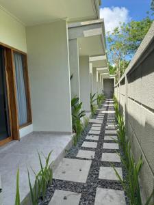 een loopbrug voor een huis met planten bij Hepy Hotel in Kuta Lombok