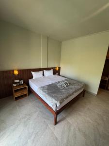 een slaapkamer met een bed en een nachtkastje bij Hepy Hotel in Kuta Lombok