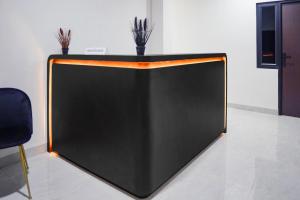 uno schermo al plasma nero e arancione in una stanza di Hotel O Khan House Syariah a Padang Altre 42 foto