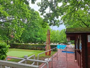 a patio with an umbrella and a table and a pool at Üdülő in Gárdony