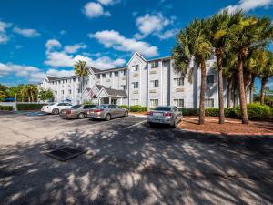 a large white building with cars parked in a parking lot at Microtel Inn & Suites by Wyndham Palm Coast I-95 in Palm Coast