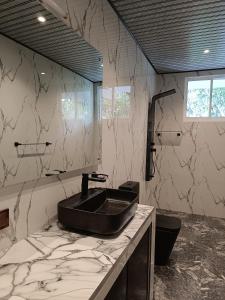 een badkamer met een zwarte wastafel op een marmeren aanrecht bij Villa Four Seasons in Mirissa +127 foto's