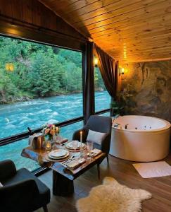 a living room with a bath tub and a table and a tableablish at Ayder Luxury Resort - Riverside Villas & Bungalows in Çamlıhemşin