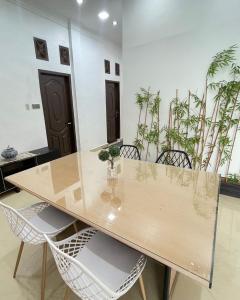 a dining room with a wooden table and chairs at Utama Guest House Kuta Alam in Banda Aceh
