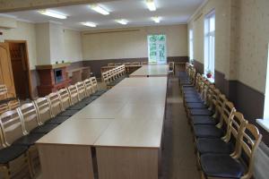 een grote vergaderzaal met een lange tafel en stoelen bij Latvijas Sarkanā Krusta viesnīca in Rēzekne