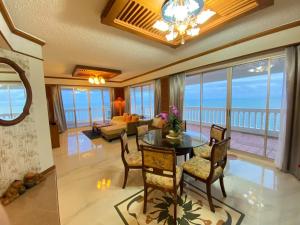 a living room with a table and chairs and the ocean at Gamers Residence in Ban Nong Chaeng