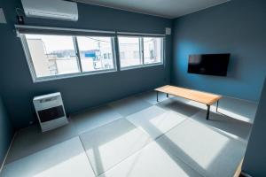 een kamer met een tafel en een televisie. bij B Cycleトリプルルーム in Biei