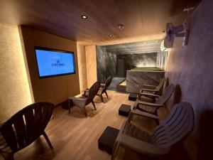 una camera con sedie e TV a schermo piatto di Hotel LiVEMAX Umeda Central ad Osaka Altre 59 foto