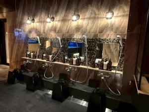 un bagno con una fila di lavandini e specchi di Hotel LiVEMAX Umeda Central ad Osaka