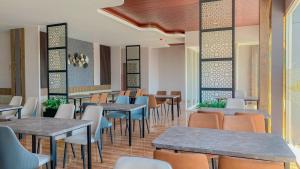 une salle à manger avec des tables et des chaises dans un restaurant dans l'établissement Azana Style Hotel Jombang, à Peterongan