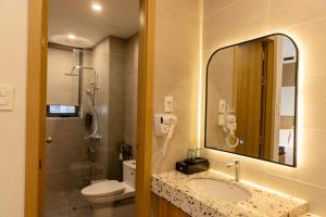 ein Badezimmer mit Waschbecken, Toilette und Spiegel in der Unterkunft C&M Hotel in Phan Rang