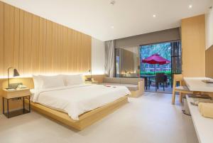 een slaapkamer met een groot bed en een eetkamer bij Ramada Resort by Wyndham Khao Lak in Khao Lak