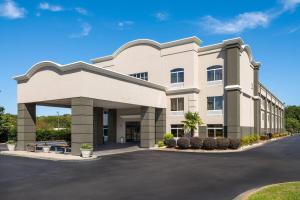 a large white building with a parking lot at La Quinta by Wyndham Florence in Florence