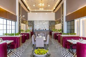 ein Esszimmer mit Tischen und Stühlen und einem Kamin in der Unterkunft The Madelinne Hotel in Muzaffarnagar