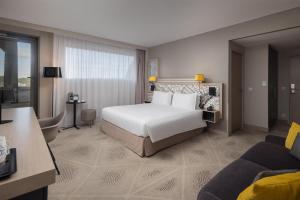 una camera d'albergo con un letto e un divano di Hilton Garden Inn Bordeaux Centre a Bordeaux Altre 84 foto