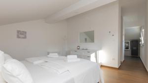 ein weißes Schlafzimmer mit einem weißen Bett und einer Küche in der Unterkunft Villa Anteo-Split by Villas Guide in Košute + 33 Fotos