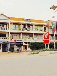 un bâtiment avec une enseigne devant lui dans l'établissement Vine Inn Mbarara, à Mbarara