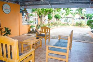 a group of wooden chairs and tables on a patio at Namasté Olango Guest House in Olango Island