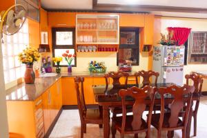a kitchen with orange walls and a table and a refrigerator at Namasté Olango Guest House in Olango Island