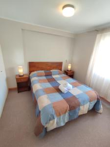 a bedroom with a large bed with two lamps on tables at Privado y Acogedor in Puerto Montt